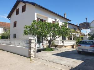 uma casa branca com um carro estacionado em frente dela em Assato Retro Apartment em Vodice