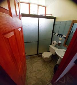 a bathroom with a toilet and a sink at Yubarta Lodge in Uvita