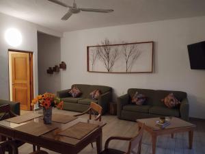 Sala de estar con 2 sofás y mesa en Casa Gekos Cuijas, en Cancún
