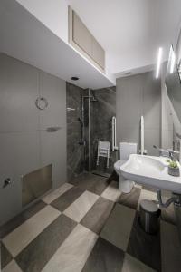 a bathroom with a sink and a shower and a toilet at Light of Faros apartments in Petalidi