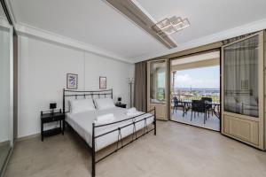 a bedroom with a bed and a balcony at Light of Faros apartments in Petalidi