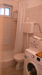 ein Badezimmer mit Waschmaschine und Toilette in der Unterkunft Swiss holiday 4 in Split + 2 Fotos