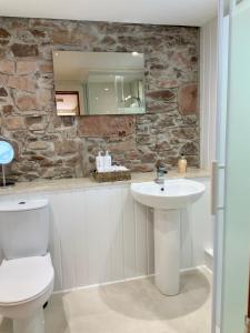 uma casa de banho com um WC branco e um lavatório. em No 10 The Cottage em Inverness