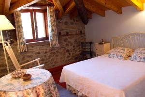 1 dormitorio con cama, mesa y ventana en Casa Rural La Lastría, en Villar