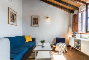 a living room with a blue couch and a table at Casa Sol - traditional village house with pool and view in Pinos del Valle