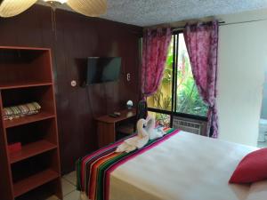 a bedroom with a bed with two stuffed animals on it at Hotel Antiguo in Antiguo Cuscatlán