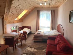a room with a bed and a couch and a table at Gościniec Twoje Mazury nad jeziorem Śniardwy tuż obok plaży in Nowe Guty