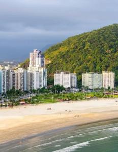 uma praia com um monte de edifícios e pessoas nela em Ilha Porchat Hotel em São Vicente