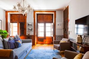 リスボンにあるAlfama Terrace Apartment With Authentic XVIII Tiles And Historic Notes 3 Bedrooms & 2 Bathrooms ACのリビングルーム(ソファ、テレビ付)