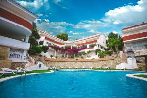 a swimming pool in front of a building at Los Palmitos Peñiscola in Peñíscola