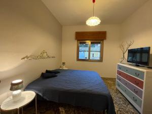 um quarto com uma cama, uma televisão e uma mesa em casa in spiaggia em Marina di Pescoluse