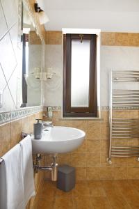 ein Bad mit einem Waschbecken und einem Spiegel in der Unterkunft Green Park in Corbara