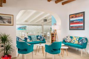 a living room with blue couches and chairs at Hotel Ristorante La Conchiglia in Cala Gonone