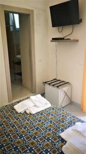 a bedroom with a bed with a tv on the wall at Visitponza - La casa di Eolo in Ponza