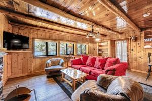 a living room with a red couch and a tv at Paradise on the Lake in Vallecito