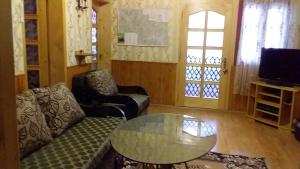 a living room with a couch and a glass table at Садиба У Галина та Йосипа in Ustʼ-Chorna