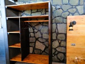 a wooden book shelf in front of a stone wall at EL PICNIC ATITLÁN in Tzununá