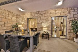 a dining room with a stone wall and a table and chairs at Villa Antonija 1607 in Ražanj