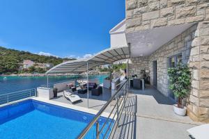 a house with a swimming pool next to the water at Villa Antonija 1607 in Ražanj