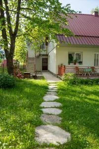 a stone path leading to a house with a tree at Apartments Grbović in Žabljak