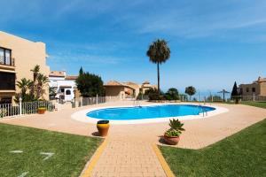 a swimming pool in a yard next to a house at Piso Benalmádena Pueblo con vista, piscina y tranquilidad in Benalmádena