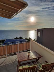 einen Balkon mit einem Tisch, Stühlen und Meerblick in der Unterkunft Apartments Vilma in Murter