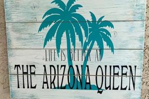 a painting of two palm trees on a wooden wall at Game Room and Pool Spacious Queen Creek Home! in Queen Creek