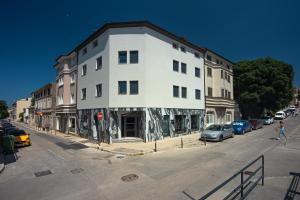 a white building on the corner of a street at Exclusive Pula City Apartments in Pula