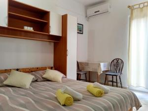 a bedroom with a bed with two yellow pillows on it at Apartments Cizmesija in Baška