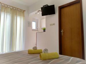 a bedroom with a bed with a television on the wall at Apartments Cizmesija in Baška