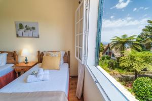 sypialnia z łóżkiem i dużym oknem w obiekcie Casa da Tia Clementina w mieście Santana