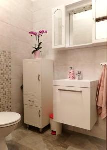 a white bathroom with a sink and a toilet at Apartments Cizmesija in Baška +8 photos