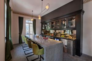 a kitchen with a bar with yellow chairs at Bachar House By 7Minds in Tel Aviv