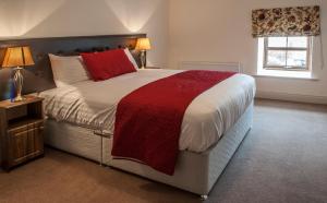 a bedroom with a large bed with a red blanket at New Forest Estate Lodges in Tyrrellspass