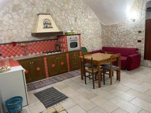 uma cozinha com uma mesa, um sofá e um fogão em Casasofé em Vico del Gargano