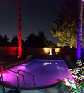 a swimming pool lit up at night with christmas lights at CATmosphere in Las Vegas