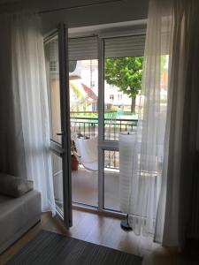 salon z przesuwnymi szklanymi drzwiami prowadzącymi na balkon w obiekcie Apartament NANO z klimatyzacją w mieście Giżycko