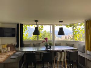 a dining room with a table and chairs and a large window at Holidayhome OMYXL in Innsbruck