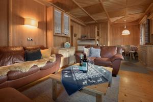 - un salon avec des canapés et une table avec une bouteille de vin dans l'établissement Apartments Heritage House Margherita, à Santa Cristina Valgardena