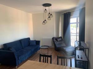 - un salon avec un canapé bleu et une chaise dans l'établissement Apartament Batory, à Toruń
