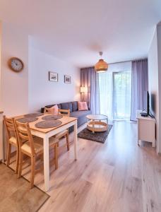 een woonkamer met een tafel en een bank bij LAGUNA Apartament Polanica Residence 29 in Polanica-Zdrój