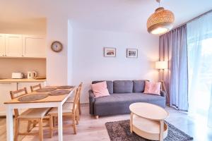 a living room with a table and a couch at LAGUNA Apartament Polanica Residence 29 in Polanica-Zdrój