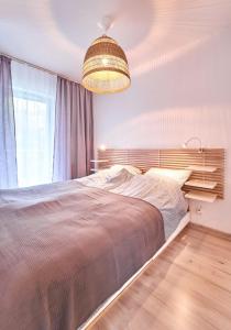 een slaapkamer met een groot bed en een kroonluchter bij LAGUNA Apartament Polanica Residence 29 in Polanica-Zdrój