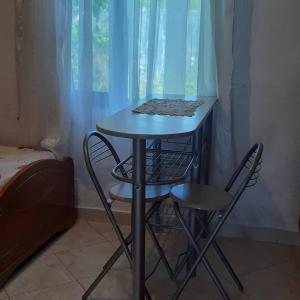 a small table and two chairs in a room at Antonio's rooms (2 single beds) in Krujë