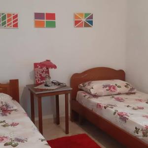 a bedroom with two beds and a table with a lamp at Antonio's rooms (2 single beds) in Krujë