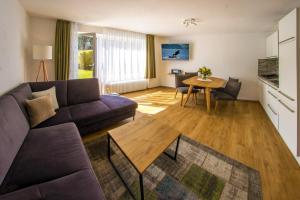 ein Wohnzimmer mit einem Sofa und einem Tisch in der Unterkunft Appartement-Hotel-Allgayer in Oy-Mittelberg
