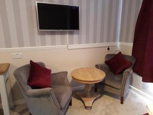 a living room filled with furniture and a tv at Fairwater Head in Axminster