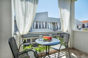 a table with a bowl of fruit on a balcony at Armyra studios in Pefkochori