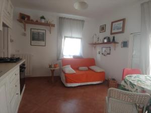 a living room with an orange chair and a window at Casa RoSiLù in Monopoli