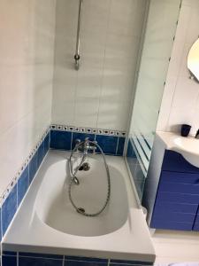 a bath tub with a shower in a bathroom at Appartement pour 4 personnes à Fort-Mahon Plage in Fort-Mahon-Plage